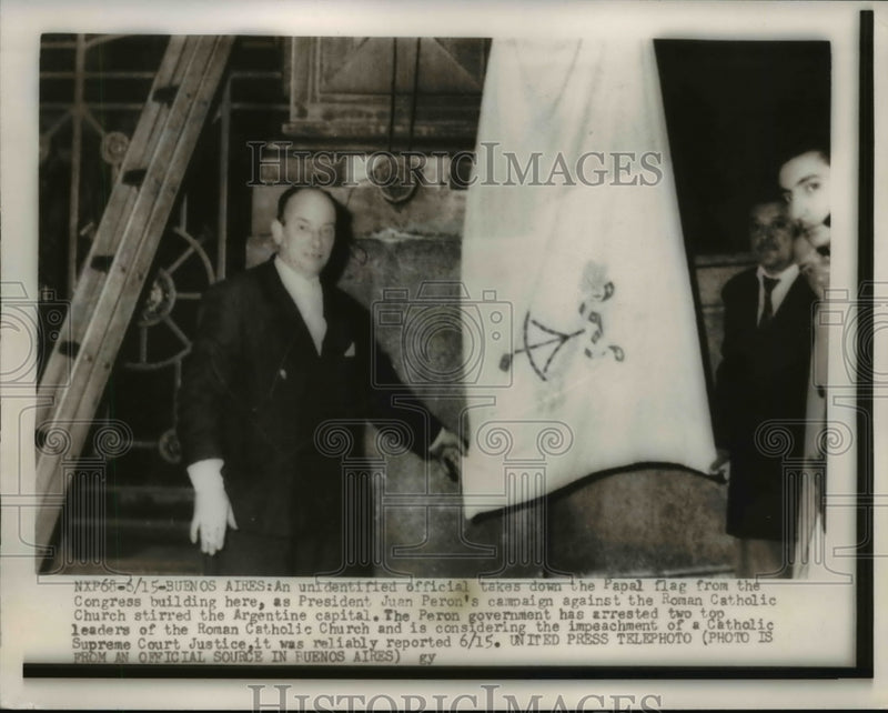 Load image into Gallery viewer, 1955 Press Photo of a man taking down the Papal flag from the Congress
