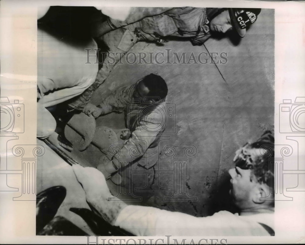 1954 Press Photo Warren Murray holds himself up while rescuers work to free him