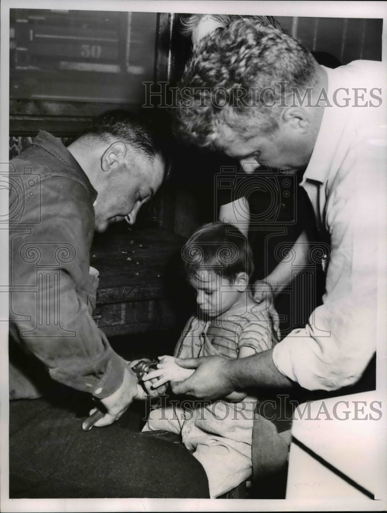 Load image into Gallery viewer, 1952 Press Photo John Brennan cutting a washer used as a ring from a finger.
