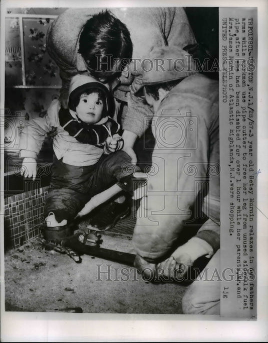 1957 Press Photo Betty Murnin being resued by her father by using a pipe cutter