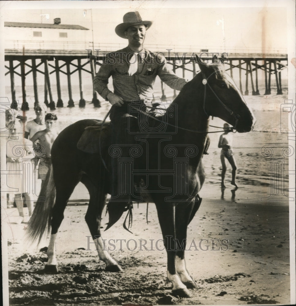 1947 Press Photo Sen. Glen Taylor seen mounting his horse "Nugget" at the beach