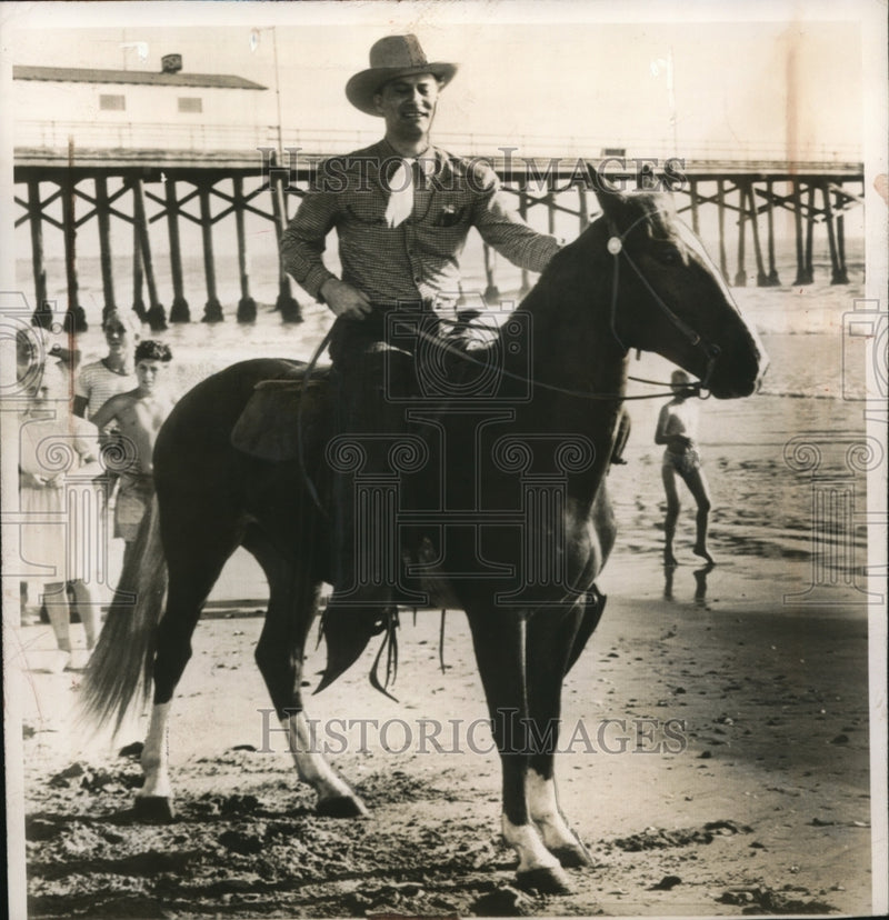Load image into Gallery viewer, 1947 Press Photo Sen. Glen Taylor seen mounting his horse "Nugget" at the beach
