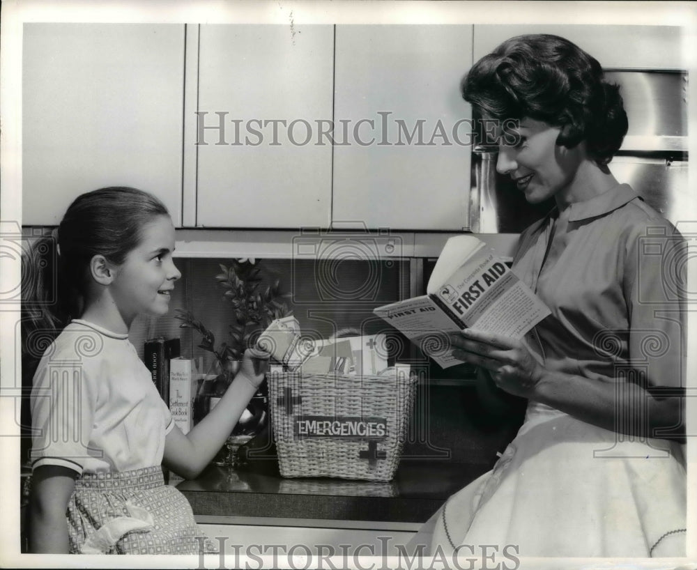 1961 Press Photo A woman & daughter with a home first aid kit