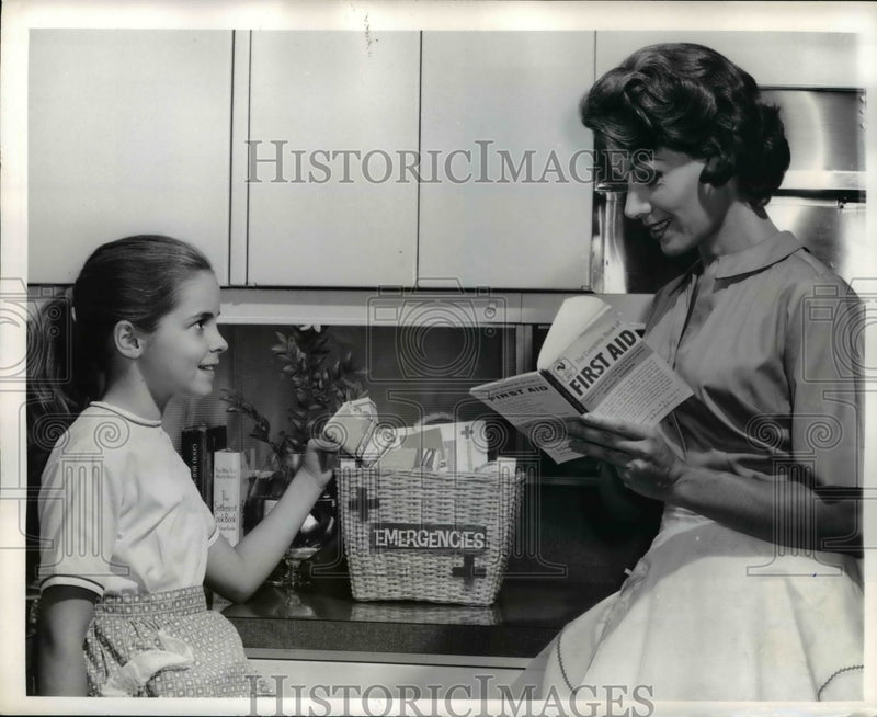 Load image into Gallery viewer, 1961 Press Photo A woman &amp; daughter with a home first aid kit
