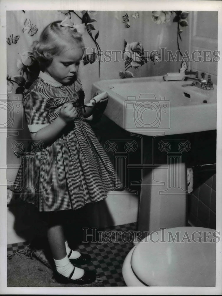 Load image into Gallery viewer, 1955 Press Photo Young Girl Applies Toothpaste to Toothbrush Dental Care
