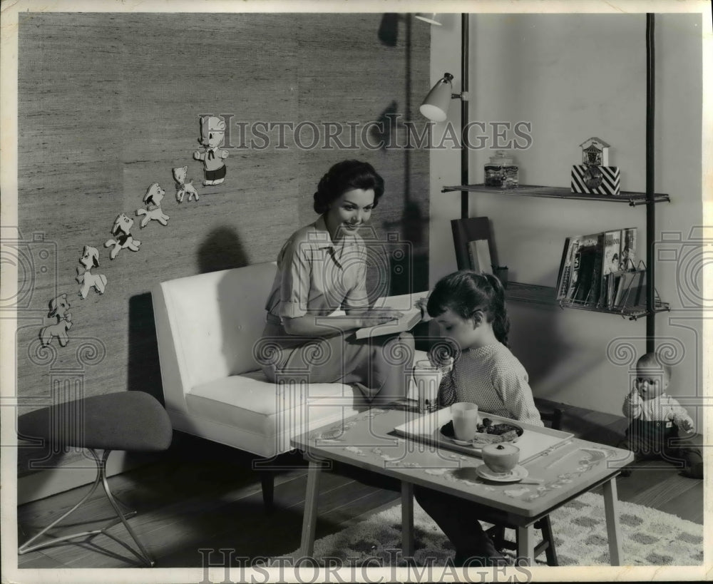 1959 Press Photo A mother with her child in his modern bedroom as she reads