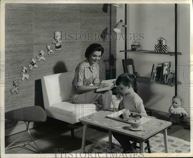 Load image into Gallery viewer, 1959 Press Photo A mother with her child in his modern bedroom as she reads
