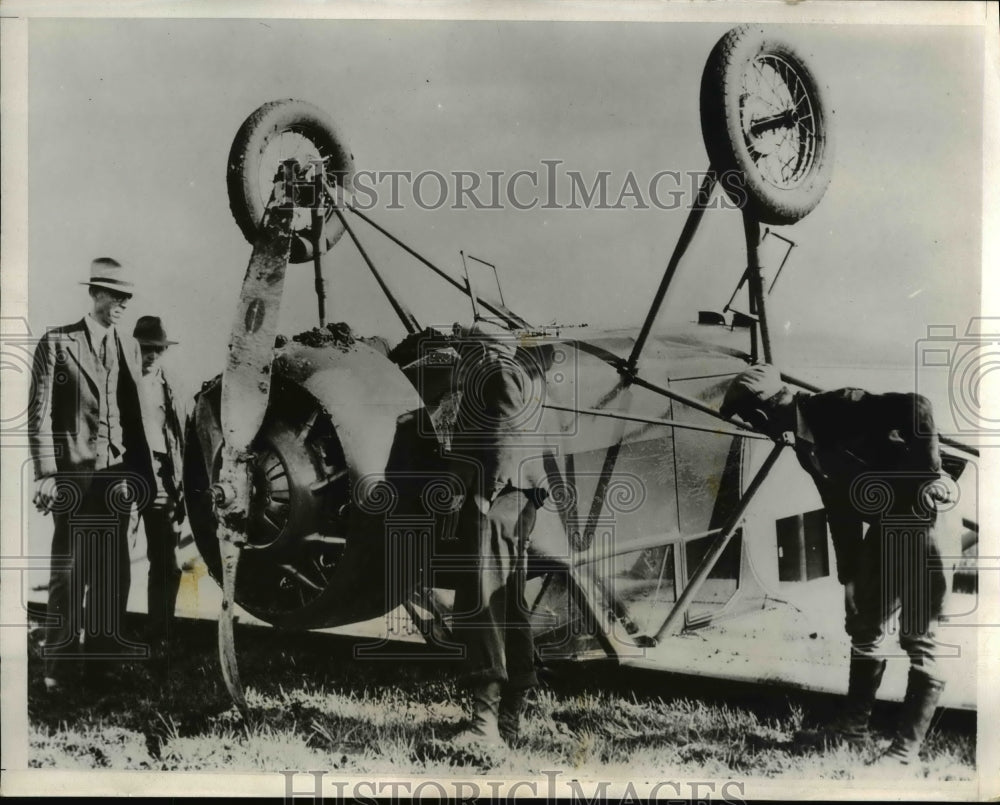 1932 Press Photo Pilot William Campbell attempting to land flipped over plane