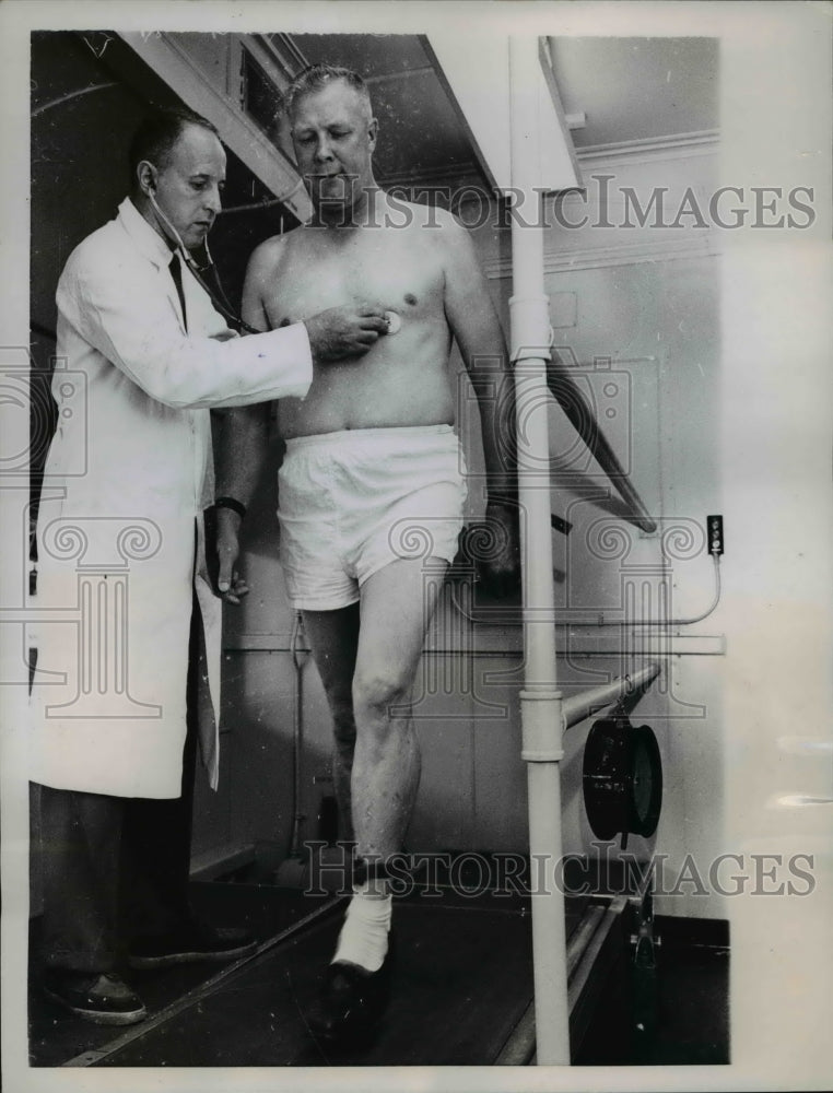 1957 Press Photo Carl Peterson is being check by Walter Carlson on a treadmill