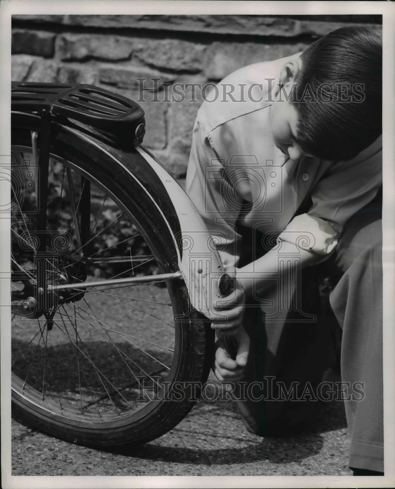 1951 Press Photo Boy Checks Bike for Light and Tail Reflector