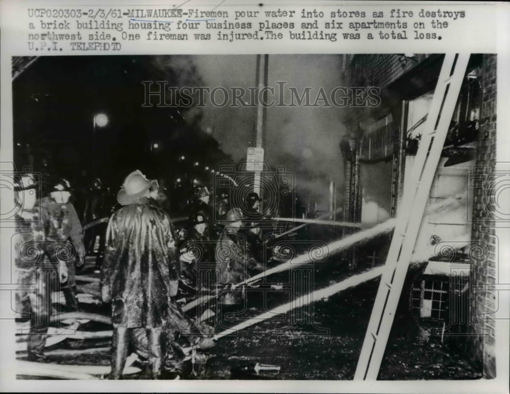 1961 Press Photo firemen pour water into stores in Milwaukee