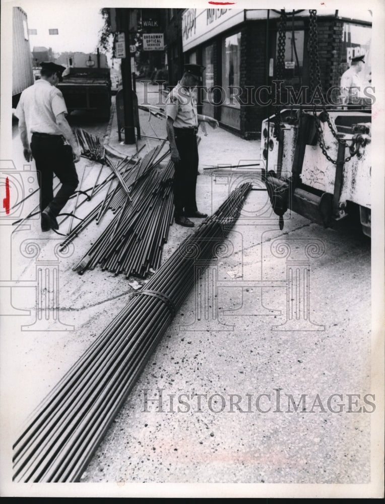 1969 Press Photo Steel Rods Roll Off Truck Injuring Woman Crossing Street
