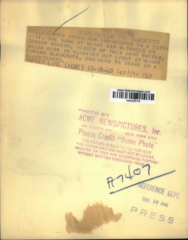 1940 Press Photo Inn Keeper in Holland Rigs Door Shield Blocks Out Light at Nigh