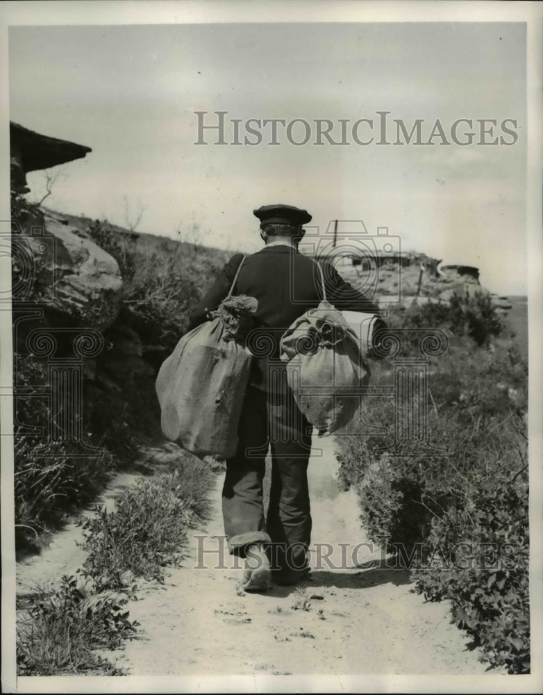 Load image into Gallery viewer, 1940 Press Photo of a transient man going walking away. - nee35623
