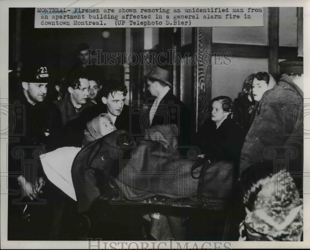1952 Press Photo Firemen and a survivor during a fire in downtown Montreal