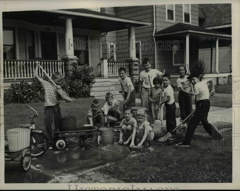 Load image into Gallery viewer, 1957 Press Photo Family Cleaning sidewalk - nee40880
