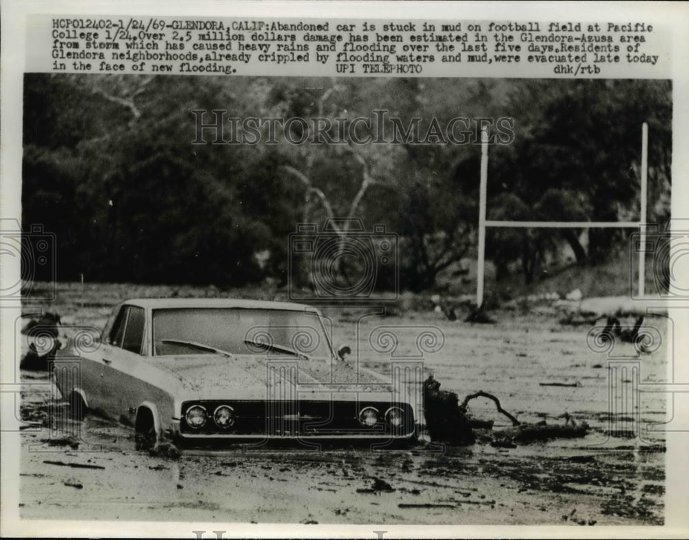1969 Press Photo Car stuck in the mud on football field at Pacific College.