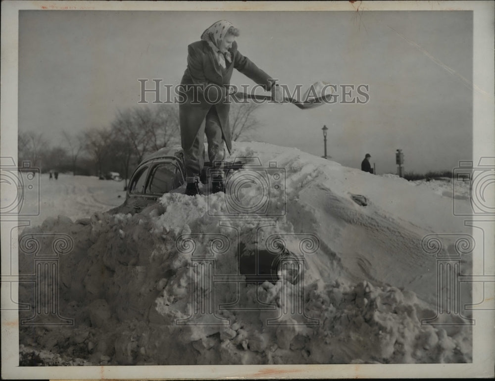 1948 Press Photo Lorraine Lueake dig her auto covered with snow in Milwaukee Wis