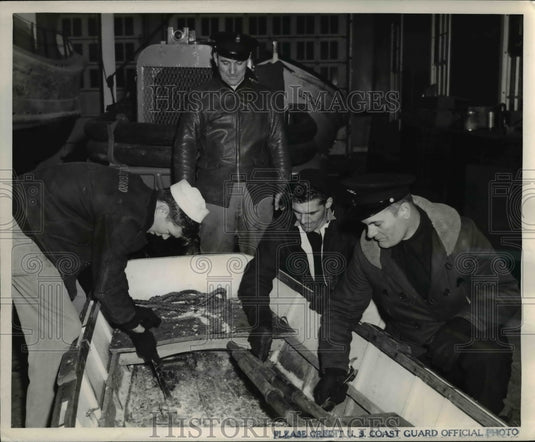 1946 Press Photo Coast Guardsmen scrape ice from skiff used in rescue operations