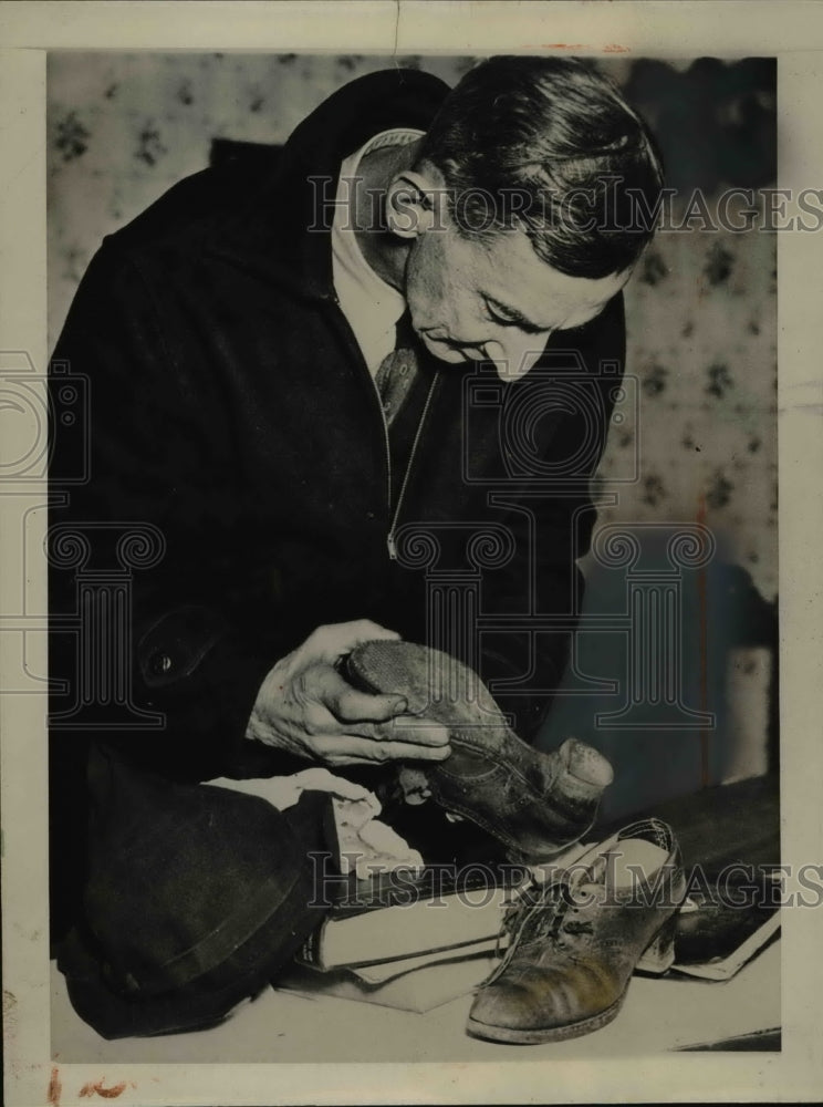 1937 Press Photo Burgess Bowman examines shoes of Helen Moyer. - nee61648