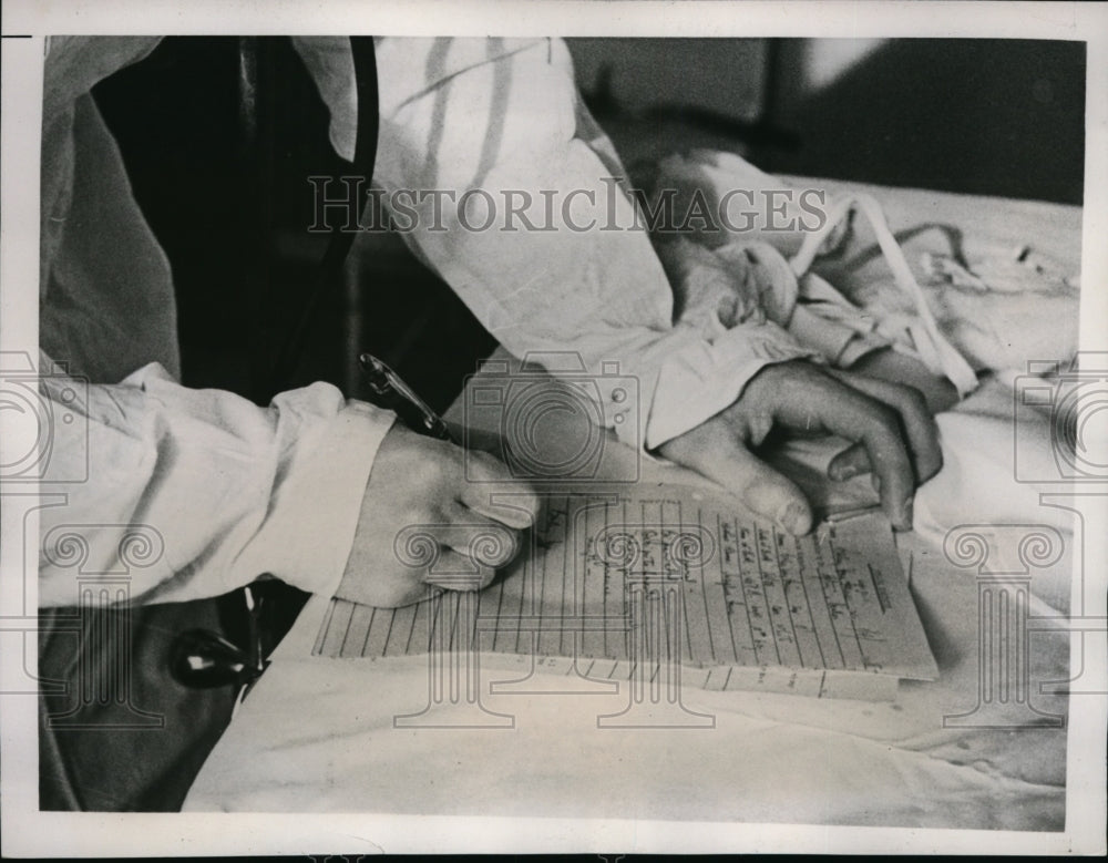 1938 Press Photo Examining Physician writes down complete record of birth