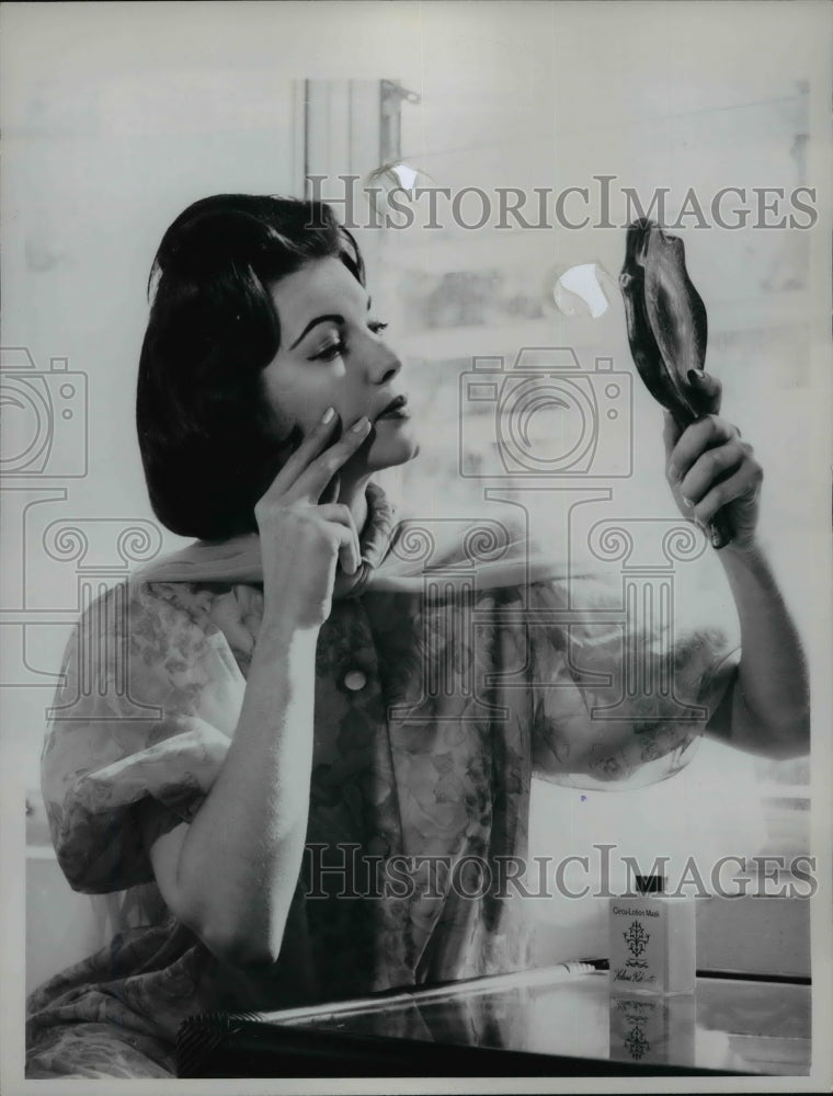 1961 Press Photo A woman applies makeup in a daily beauty skin care routine