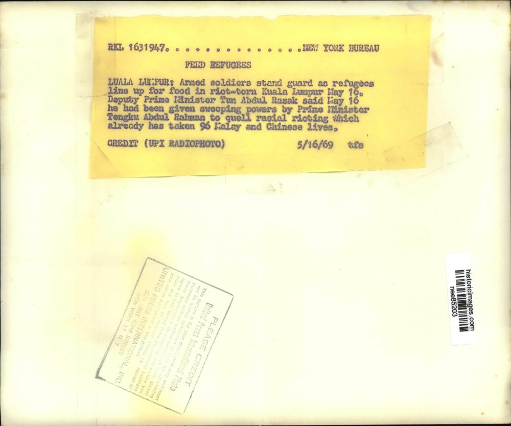 1969 Press Photo Armed Soldiers stan guard as refuguees line for food.