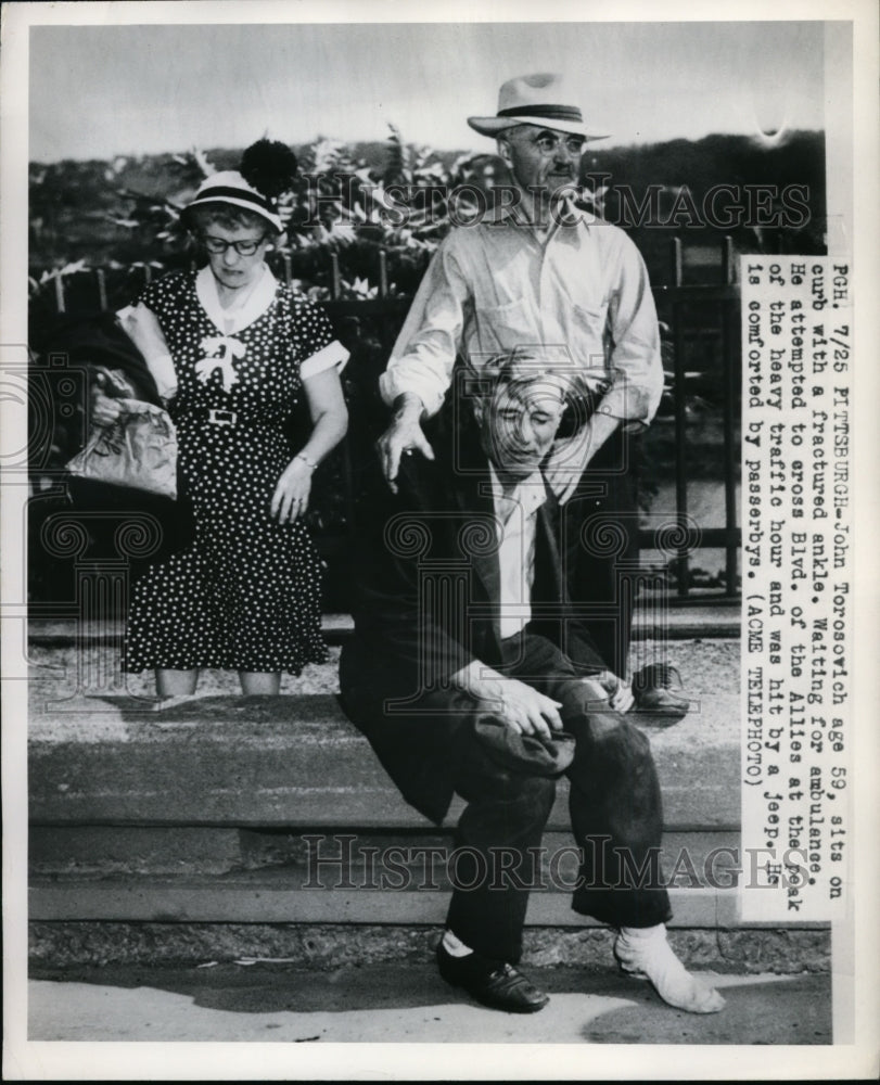 1950 Press Photo John Torosovich sits on curb with fractured ankle - nef01254