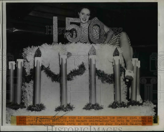 1946 Press Photo Eileen Kelly poses atop 150th birthday cake for Cleveland