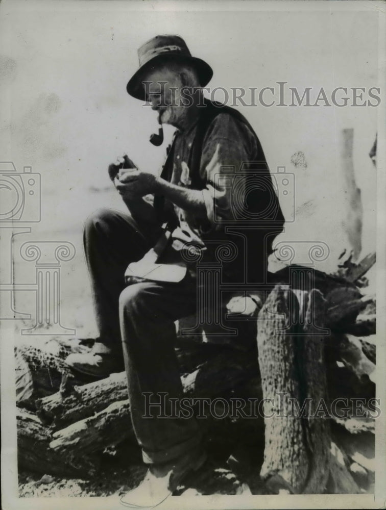 1935 Press Photo Old Man Smoking Cigar on Wood Pile - nef02288