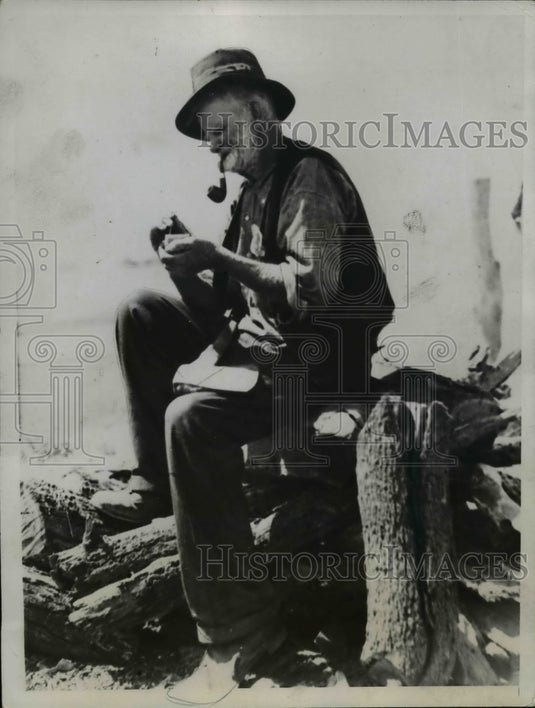 1935 Press Photo Old Man Smoking Cigar on Wood Pile - nef02288