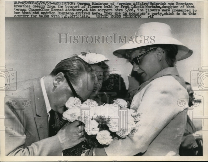 Load image into Gallery viewer, 1957 Press Photo Heinrich von Brentano Smells Flowers Given to Frau L. Werhahn

