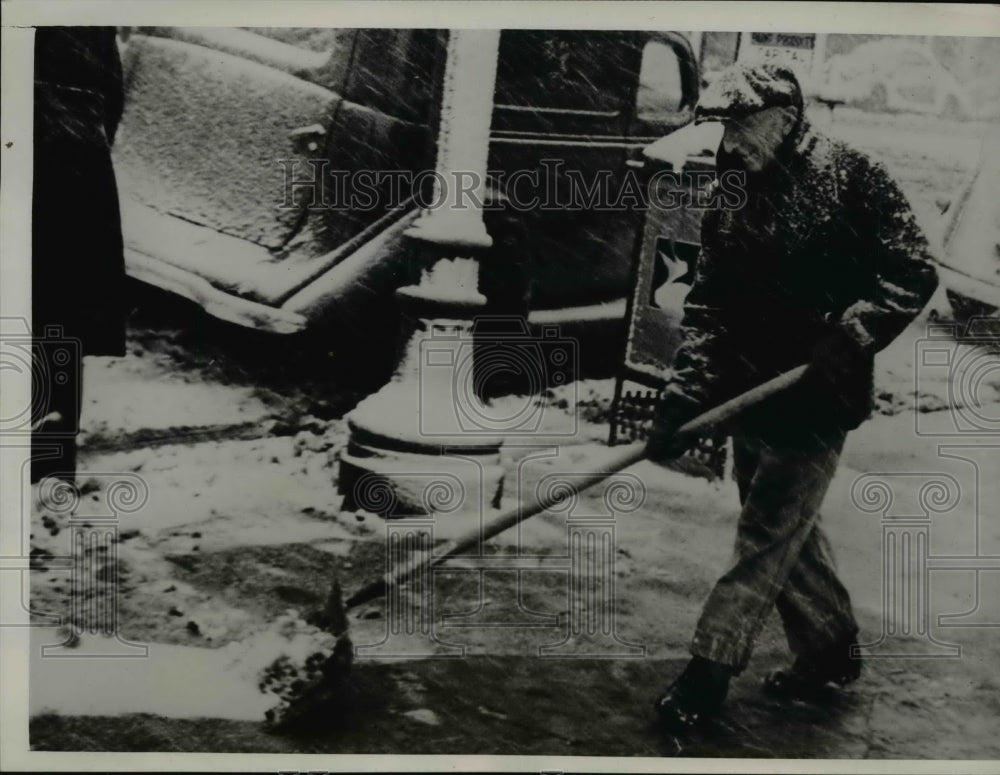 1939 Press Photo Edmontonian clears sidewalk while snow continues to fall