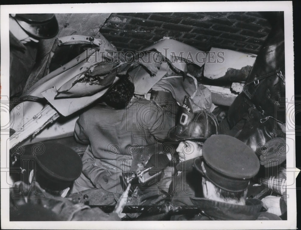 1950 Press Photo Firemen Work In Space Between Factory Wall and Switch Engine