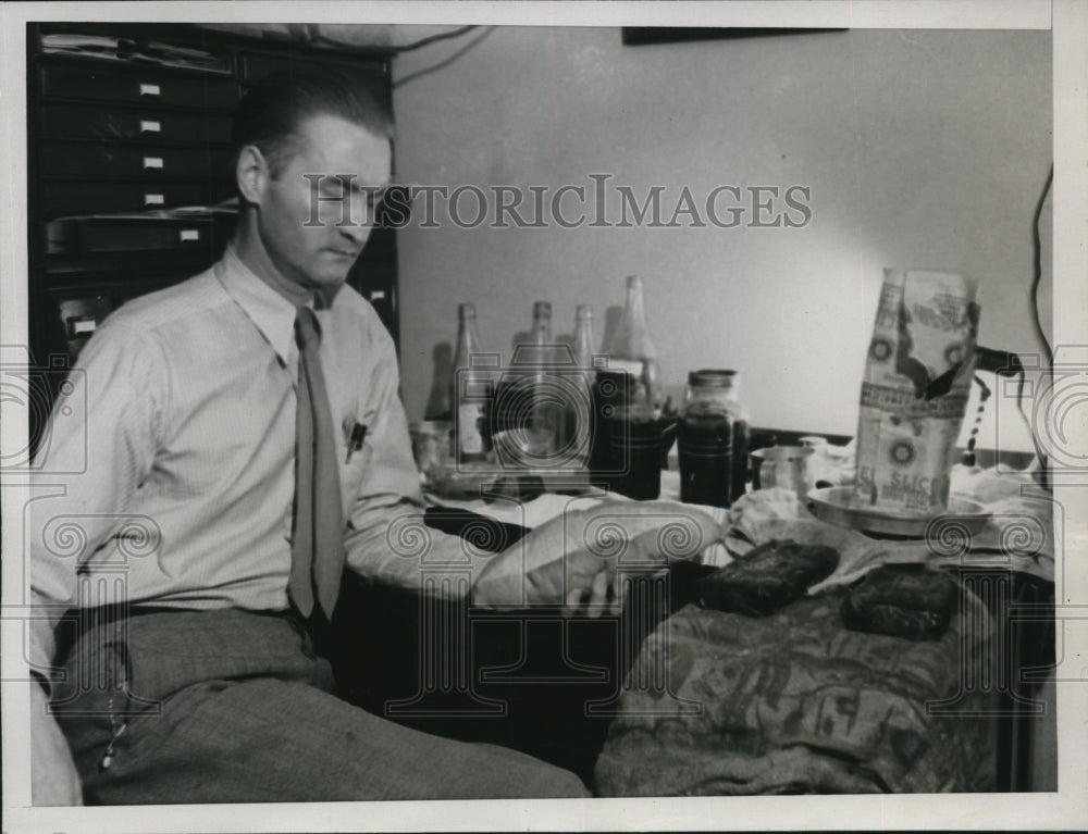 1934 Press Photo M.T Guiney Examines Food Found Where June Robles Was Imprisoned
