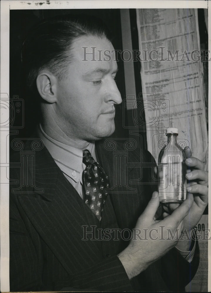1940 Press Photo Policeman Edward Egan Holds Bottle of Colorless Liquid
