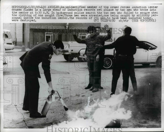 1969 Press Photo Member of Armed Forces Induction Center Douses Flames in Sheaf