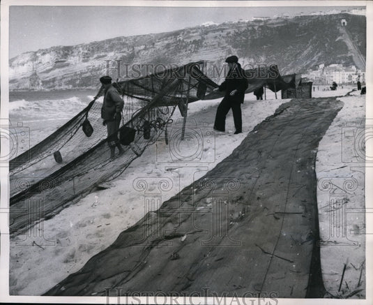 1957 Press Photo Portugal- Men Spread Fishing Nets to Dry - nef31898