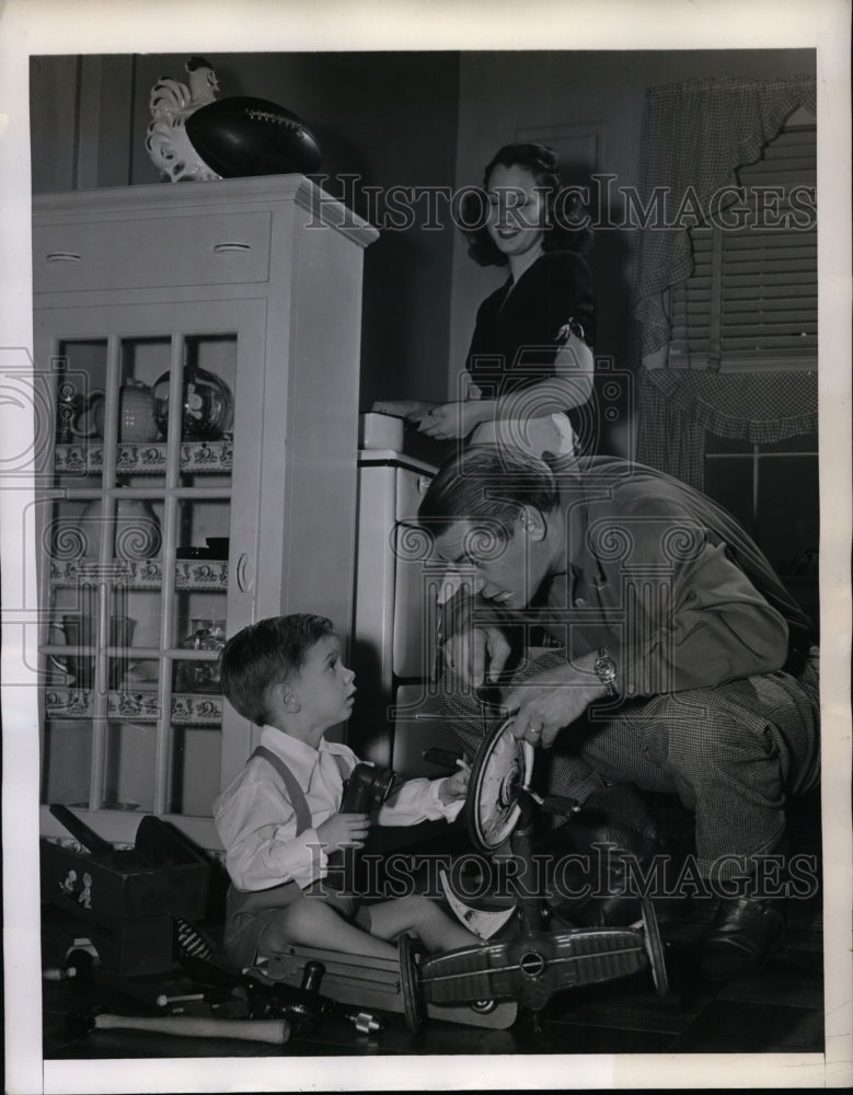 1945 Press Photo Frank Filchock of WA Redskins Helps son Johnny Fix Tricycle