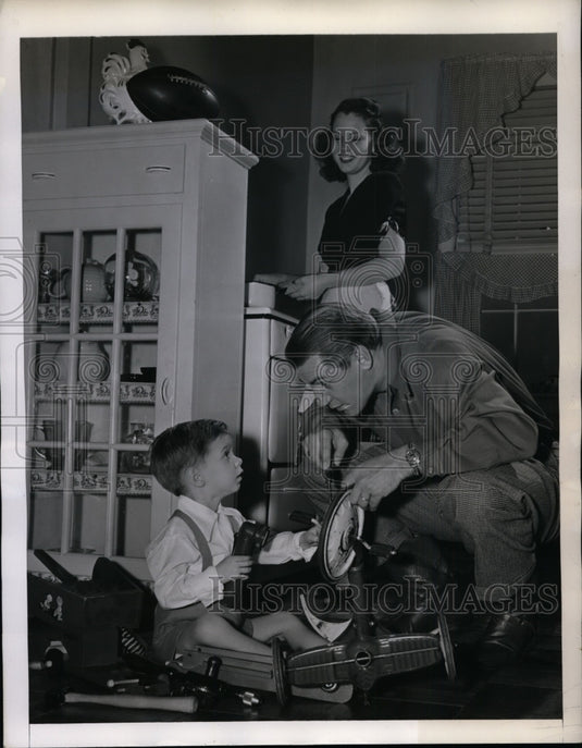 1945 Press Photo Frank Filchock of WA Redskins Helps son Johnny Fix Tricycle