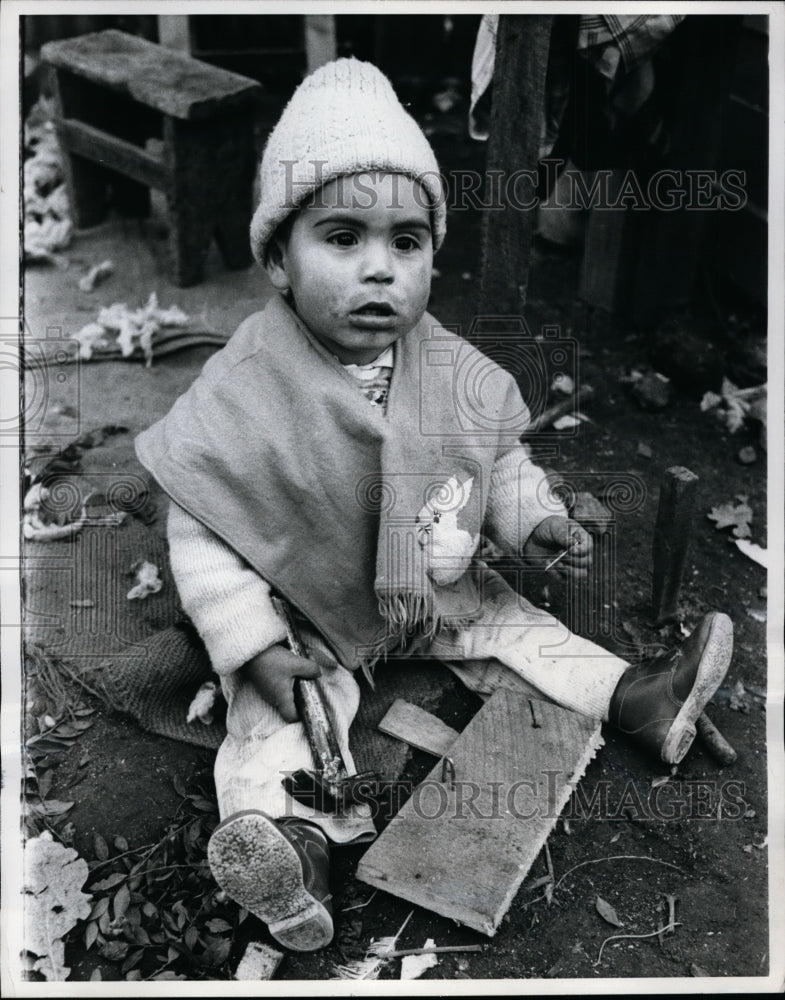 1970 Press Photo Child holds a hammer and nail on the Asentamiento - nef32708