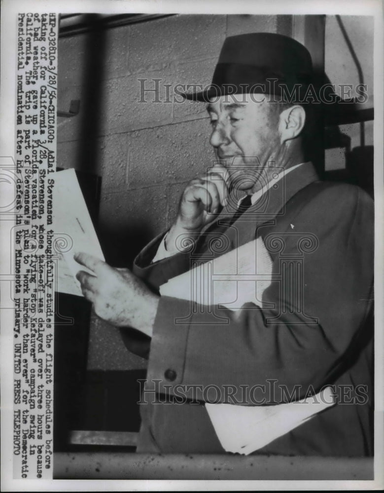 1956 Press Photo Adlai Stevenson thoughtfully studies the flight schedules