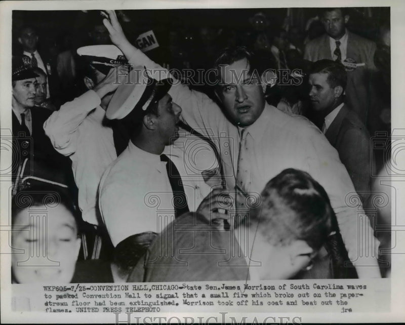 Load image into Gallery viewer, 1952 Press Photo Sen James Morrison Waves to Signal Fire on Paper Strewn Floor
