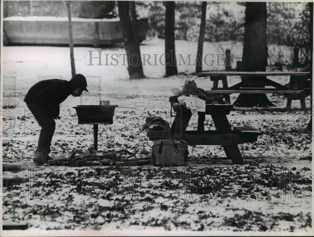 1965 Press Photo Outdoors-men blowing at charcoal in Rocky River reservation