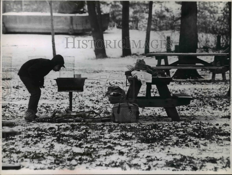 Load image into Gallery viewer, 1965 Press Photo Outdoors-men blowing at charcoal in Rocky River reservation
