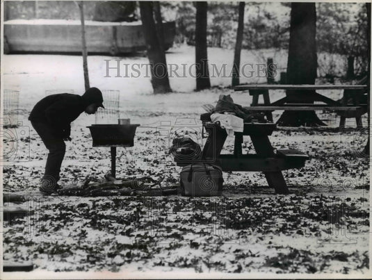 1965 Press Photo Outdoors-men blowing at charcoal in Rocky River reservation