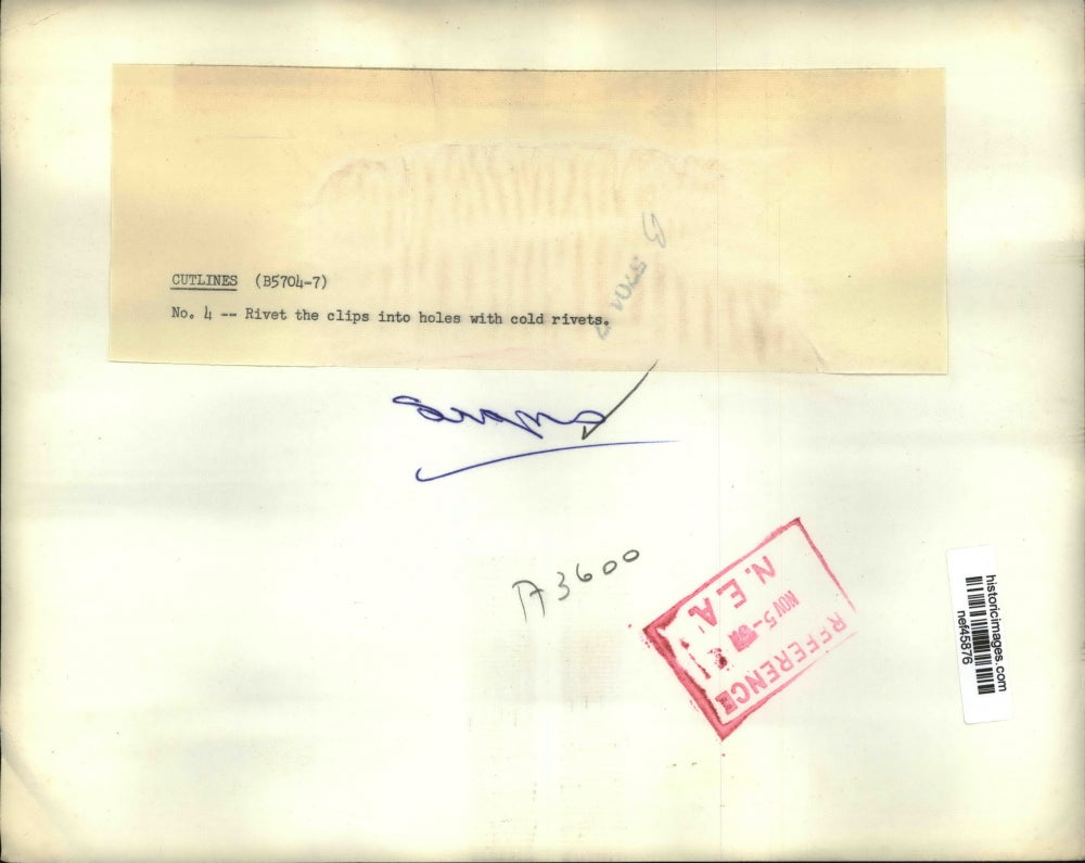 Press Photo Riveting the Clips Into Holes with Cold Rivets - nef45876