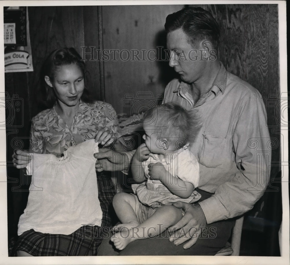 1945 Press Photo Mr. and Mrs. C.A. McGill fondle dress belonging to daughter