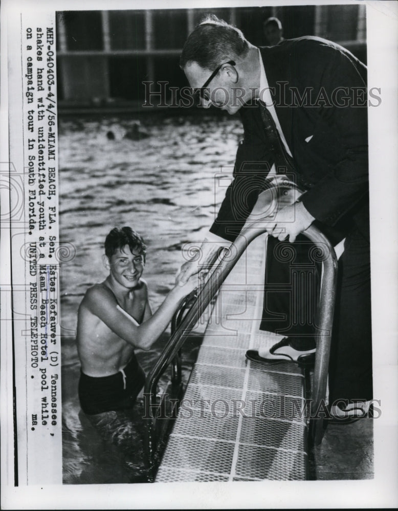 Load image into Gallery viewer, 1956 Press Photo Estes Kefauver shakes hand with youth at Miami Beach Hotel pool
