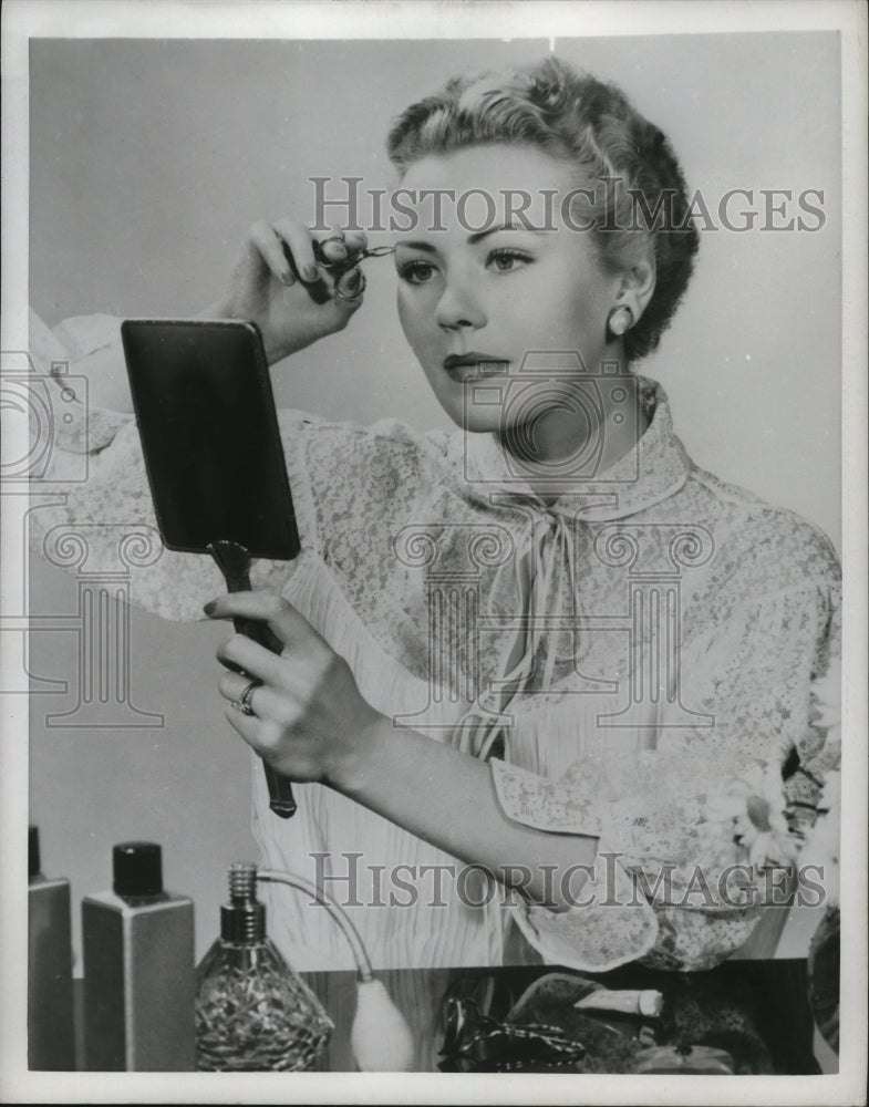 1952 Press Photo Care of eyebrows with tweezers - nef53536